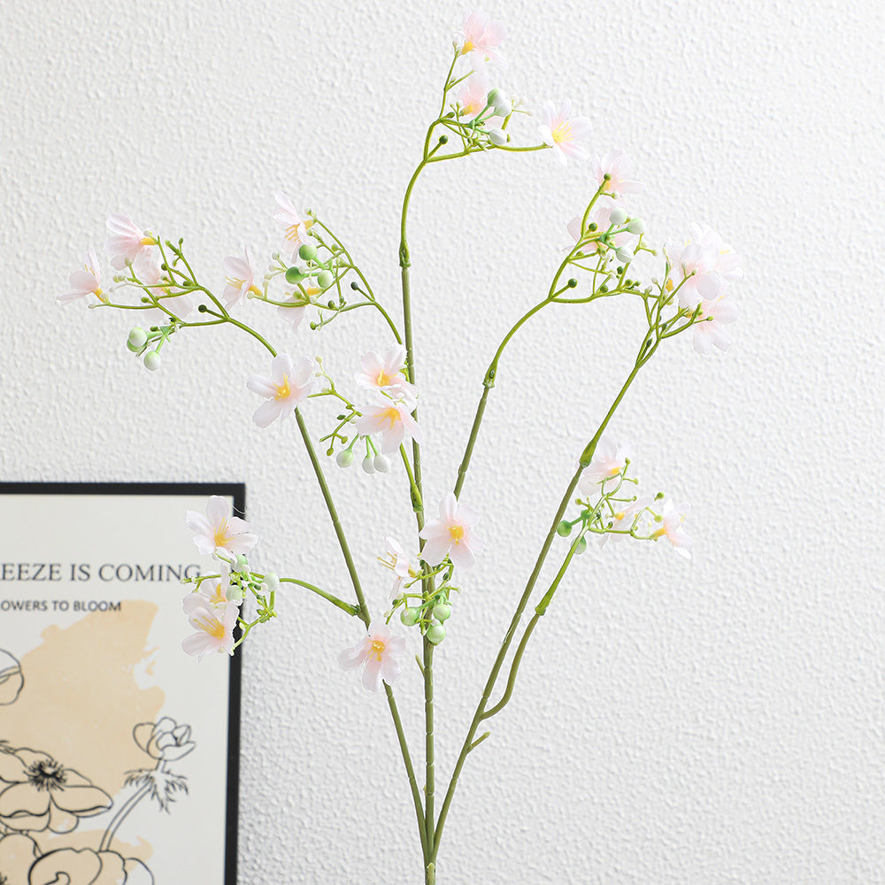 Artificial flower branch with delicate blue flowers and green berries