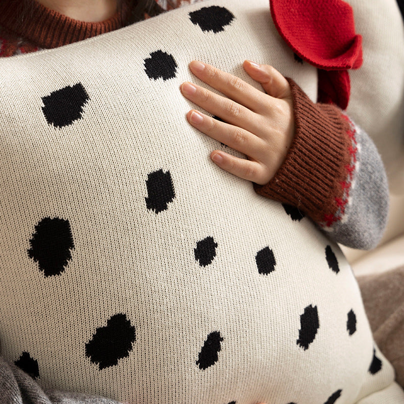 Decorative knitted cuddle pillow in the shape of a dog with a quilted body and bow detail
