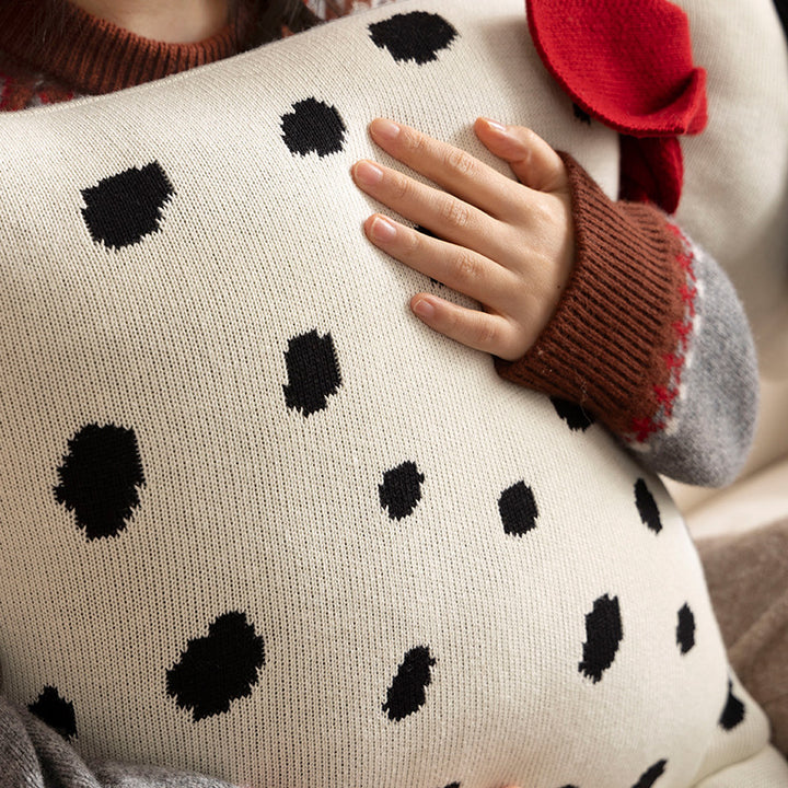 Decorative knitted cuddle pillow in the shape of a dog with a quilted body and bow detail