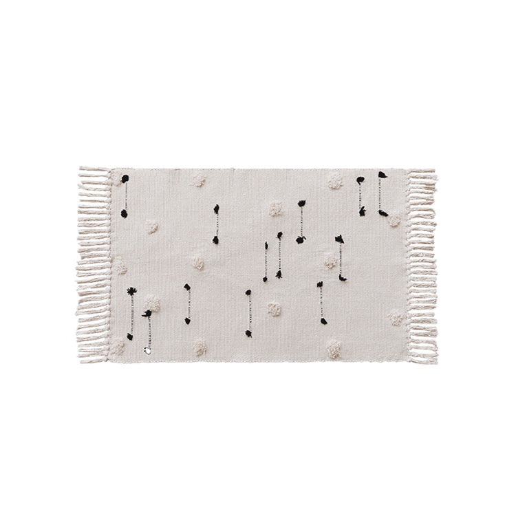 Hand-tufted bathroom mat with fringes, decorative dot-and-dash pattern and non-slip backing