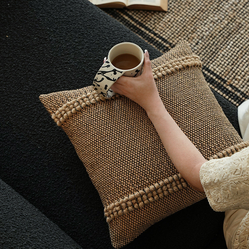 Handwoven structured cushion cover made of cotton blend with pompom trim