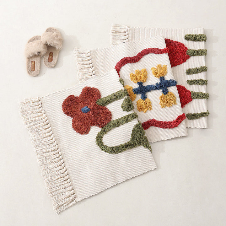 Handwoven cotton bath mat rug with tufted flower appliqué and tassels