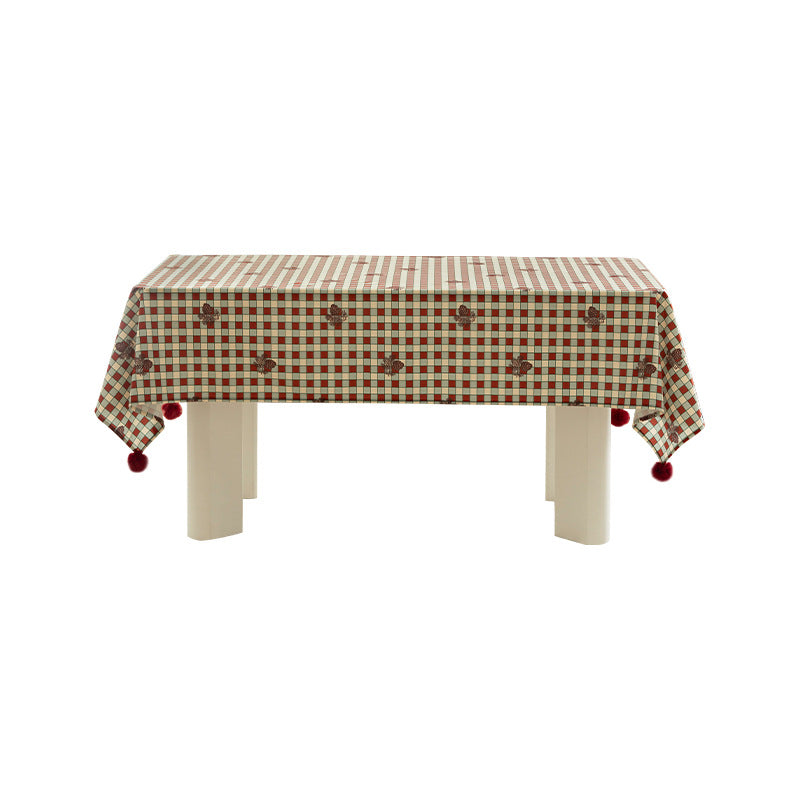 Rectangular decorative tablecloth with checkered pattern, pompom trim, and fine embroidered applique