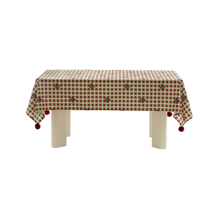 Rectangular decorative tablecloth with checkered pattern, pompom trim, and fine embroidered applique