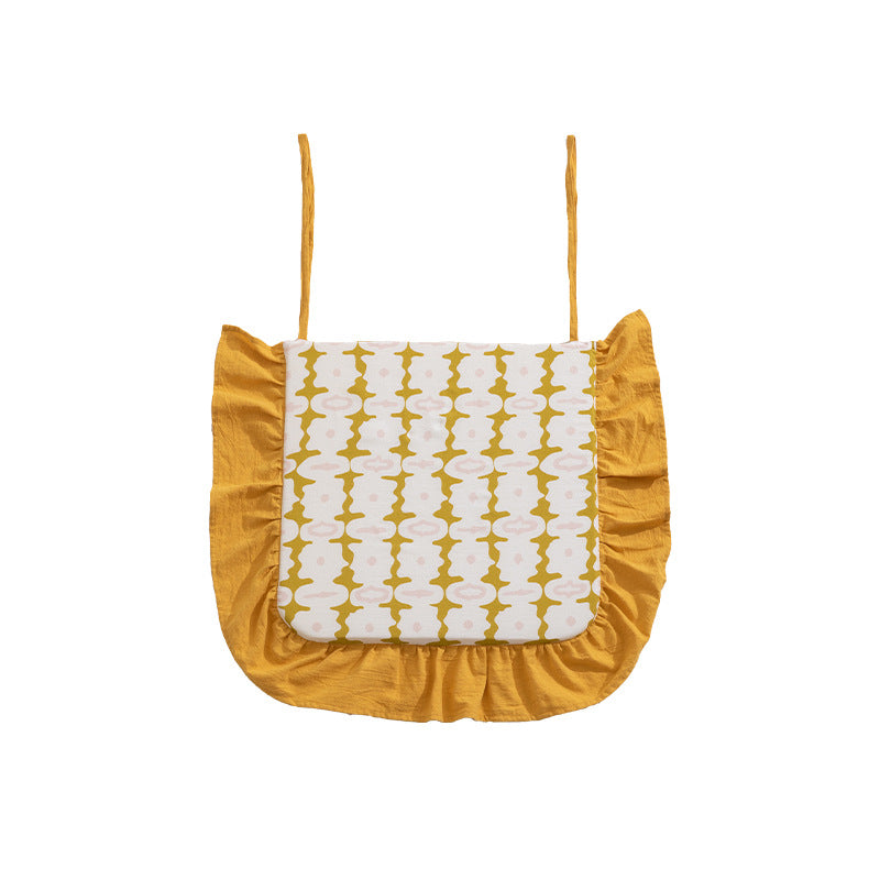 Padded chair cushion with ties, ruffled edge and embroidered hole pattern look