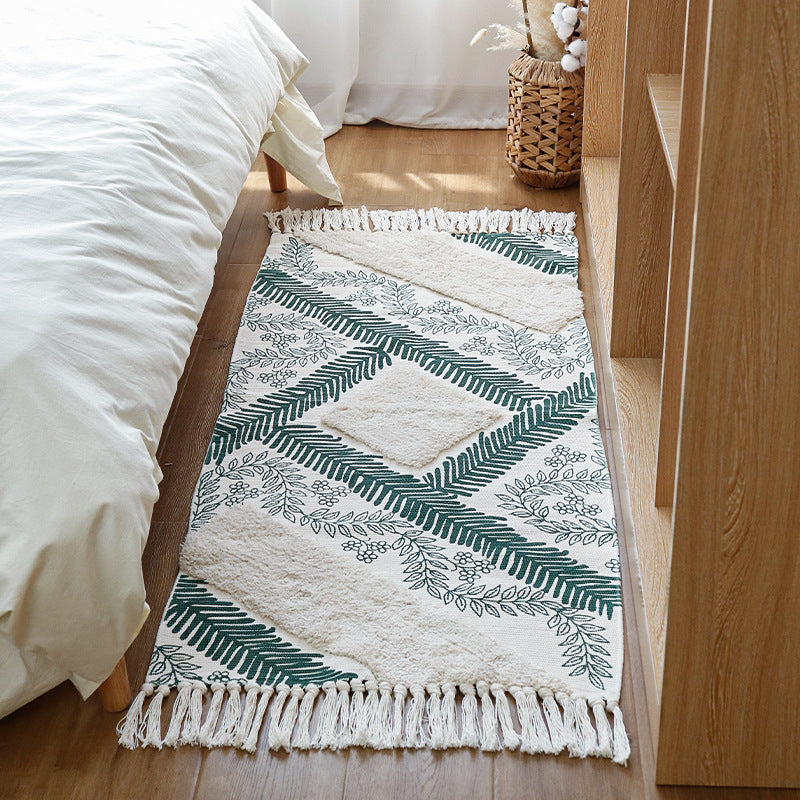 Hand-tufted cotton bath mat with botanical pattern and decorative fringes