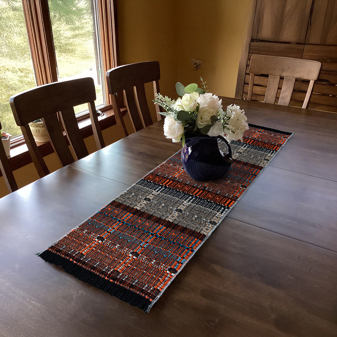 Woven table runner in ethnic look made of cotton blend with fringes