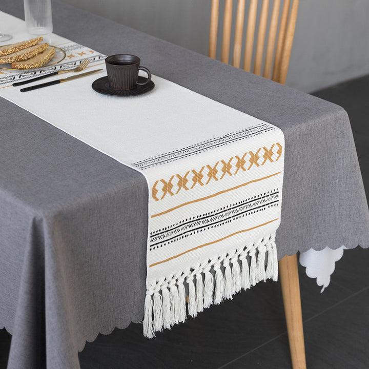 Woven Boho table runner made of cotton blend with decorative fringes and graphic stripe pattern
