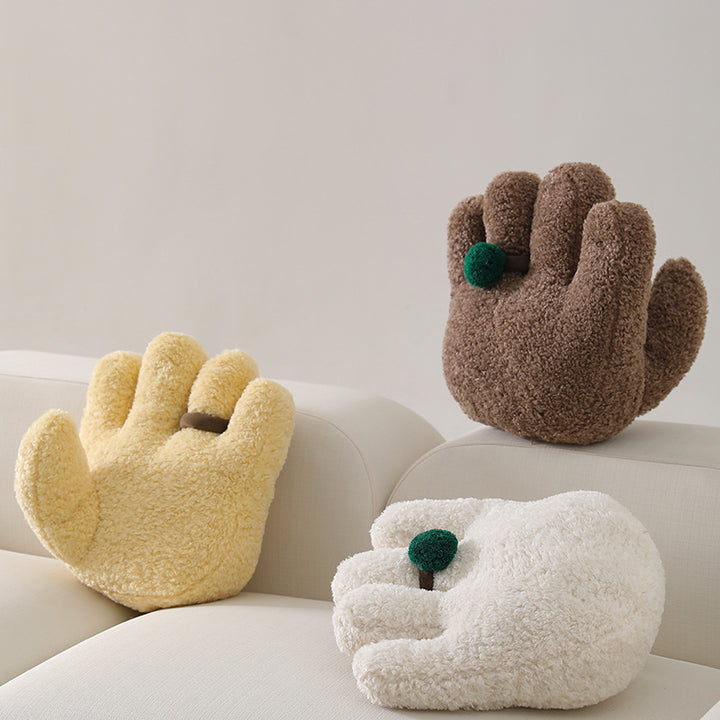 Plush decorative pillow in hand shape with pompon application