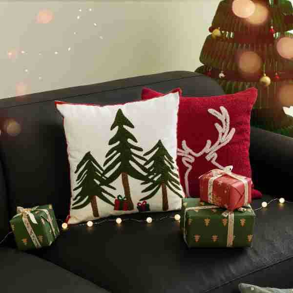 Decorative cushion cover with festive Christmas star print and pom-pom trim