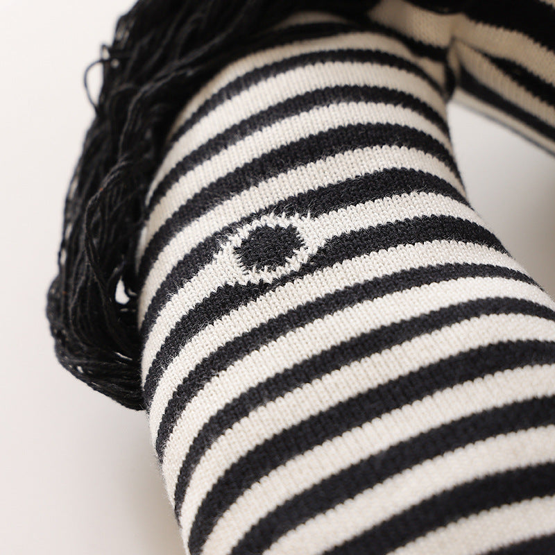 Striped decorative knitted cushion in animal shape with fringes and four-legged look