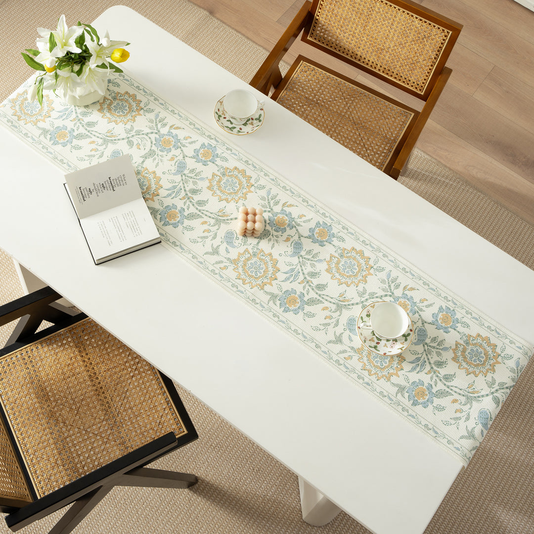 Woven decorative table runner with floral medallion borders and fringes