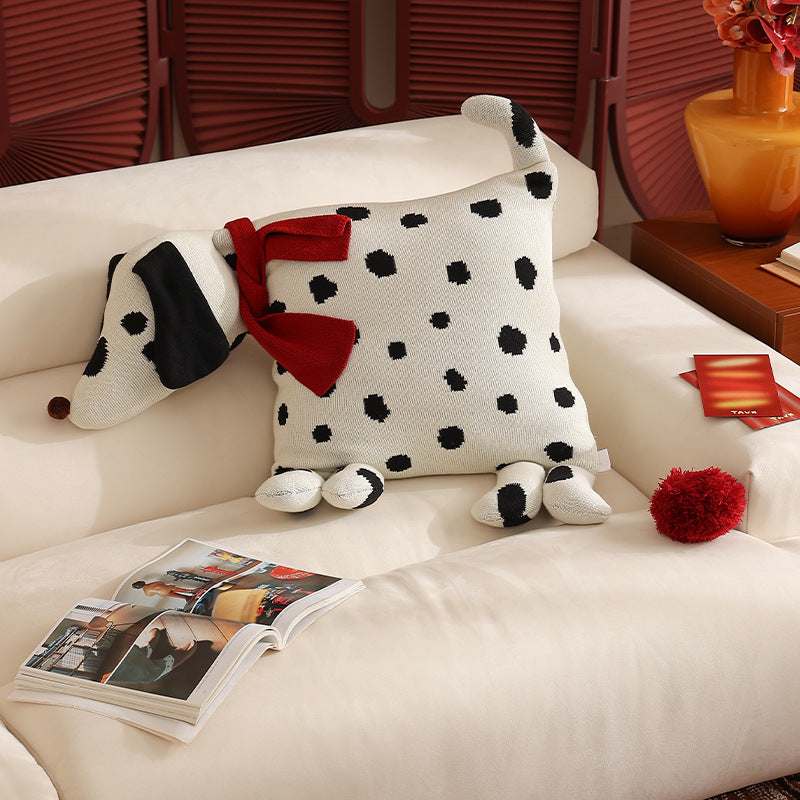 Decorative knitted cuddle pillow in the shape of a dog with a quilted body and bow detail
