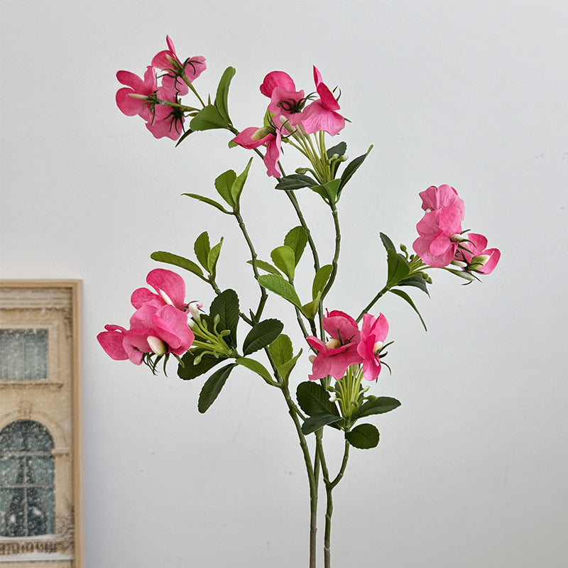 Artificial flower branch with vibrant pink flowers