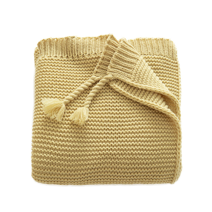 Chunky knitted cozy blanket with diamond pattern and colorful knots