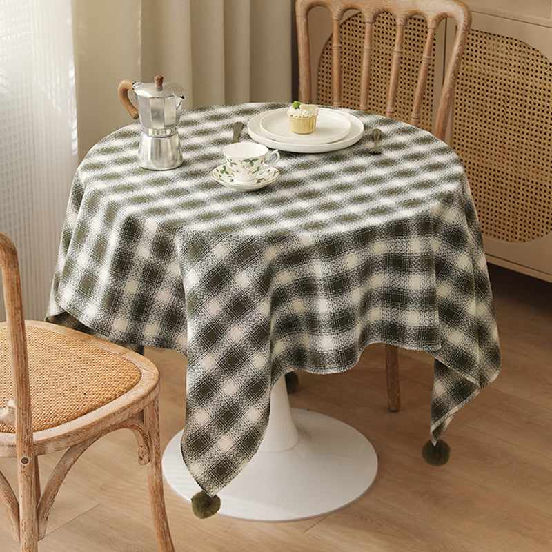 Square tablecloth made of cotton blend fabric with checkered weave pattern and pom-pom corners