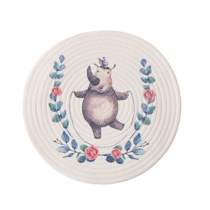 Round placemat made of woven cotton with a cute rhinoceros illustration and floral wreath