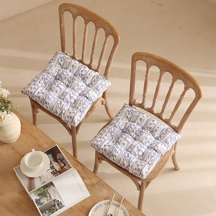 Padded quilted seat cushion with colorful button applications and non-slip underside