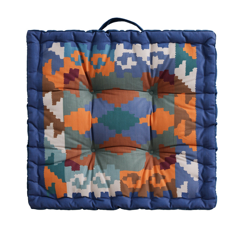 Padded seat and floor cushion with carrying handle and graphic ethno pattern