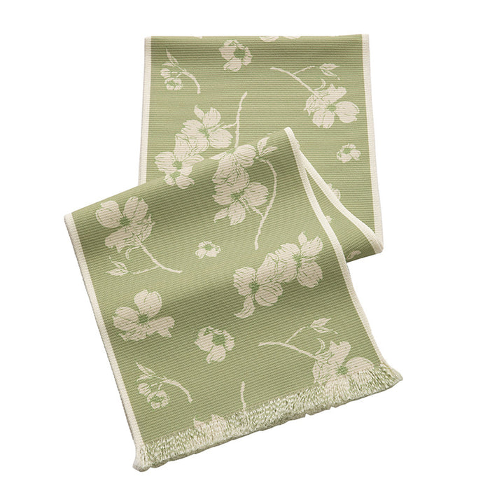 Woven table runner with floral jacquard pattern and fringed edge
