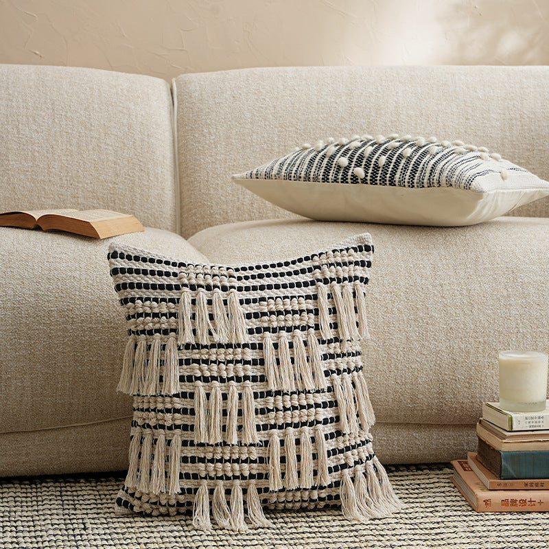 Square woven decorative pillow cover with tiered tassels and textured cotton surface