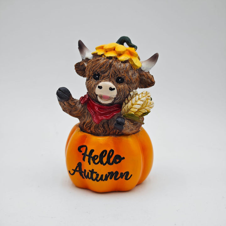 Funny decorative figure of a Highland cow in pumpkin costume
