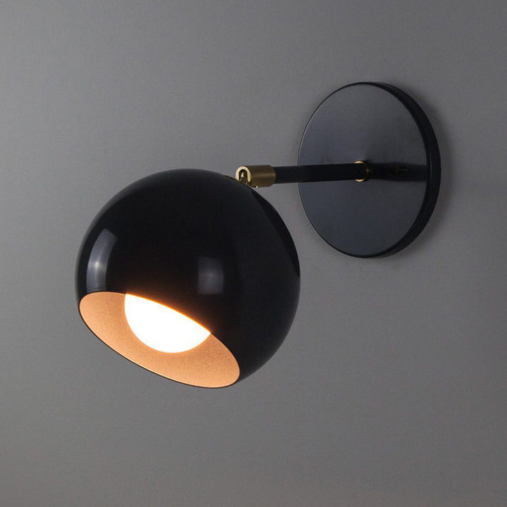 Adjustable matte metal globe wall lamp with brass pivot arm