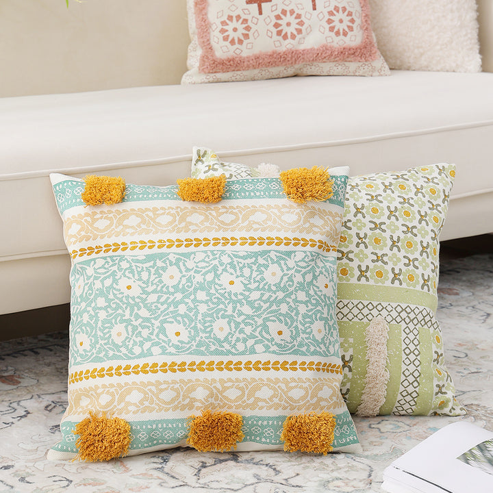 Woven decorative pillow with botanical jacquard pattern and pom-pom trim