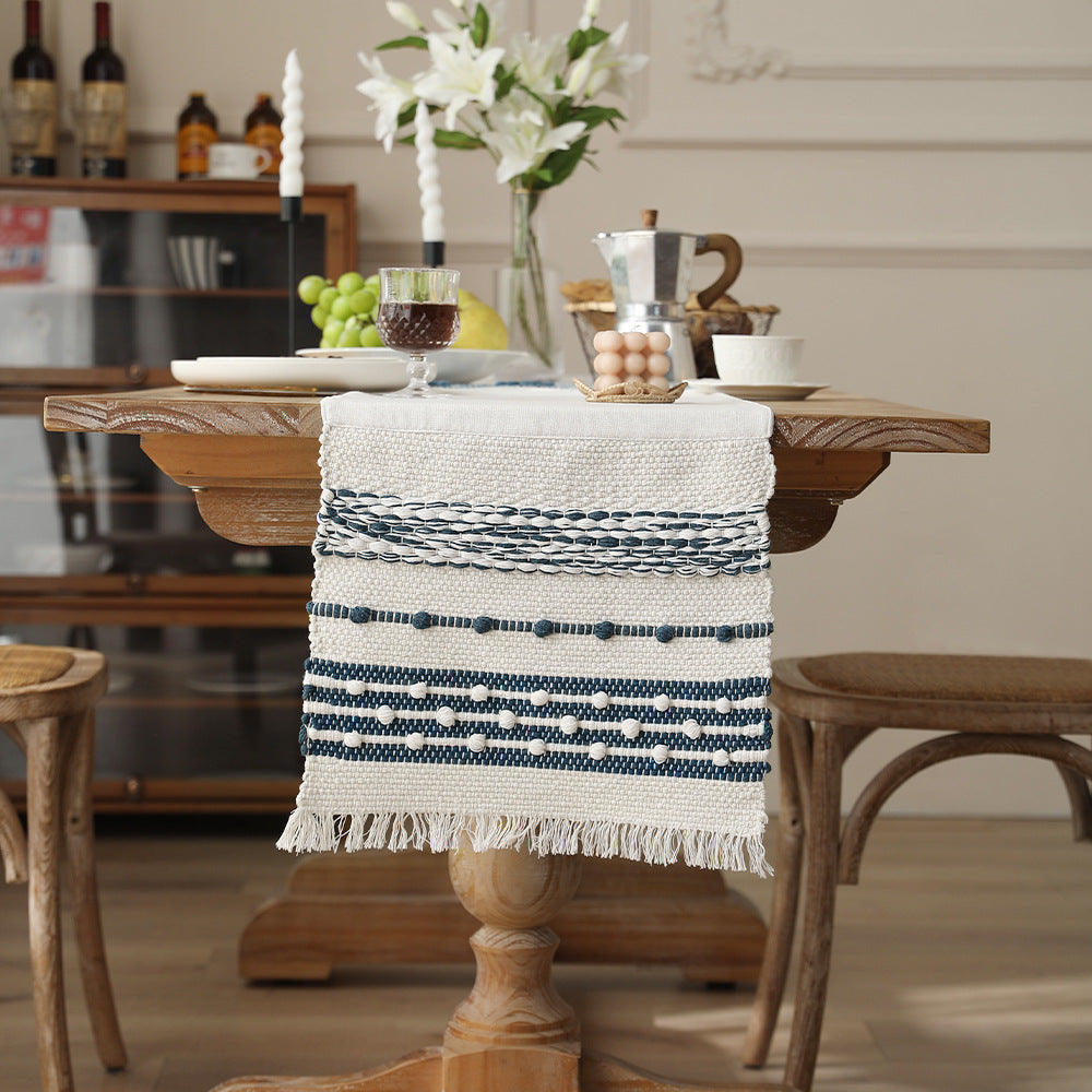 Woven cotton table runner with textured tufting and fringed border