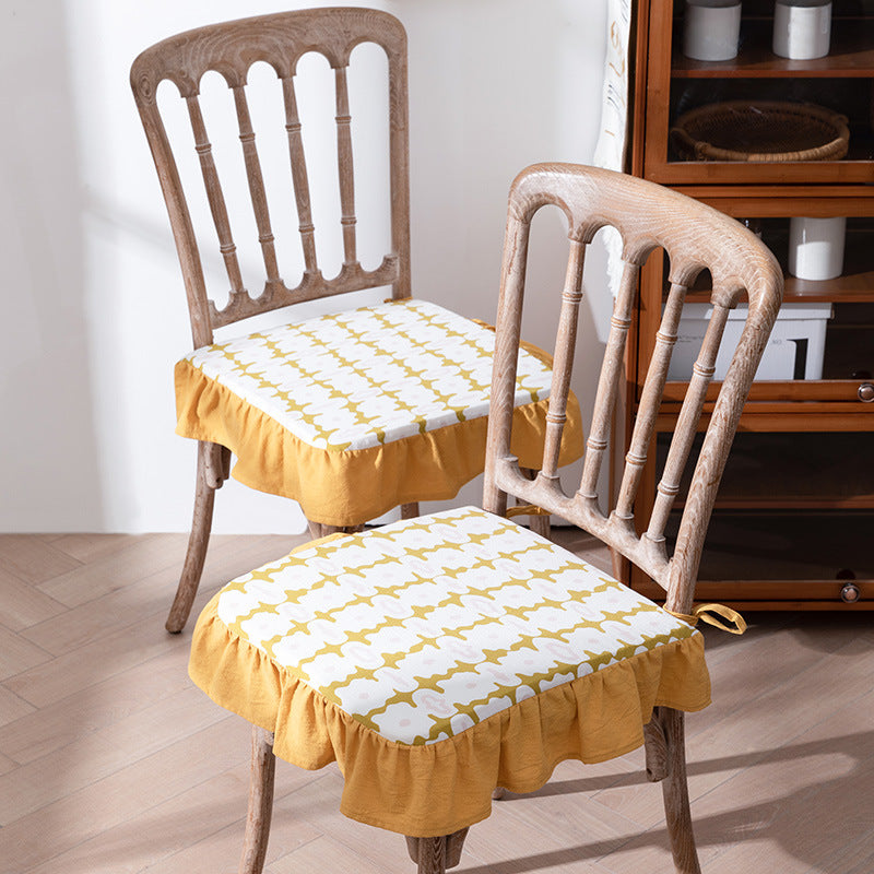 Padded chair cushion with ties, ruffled edge and embroidered hole pattern look
