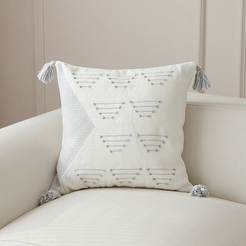 Decorative woven cushion cover with geometric tuft-relief and tassels