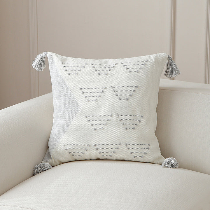 Decorative woven cushion cover with geometric tuft-relief and tassels