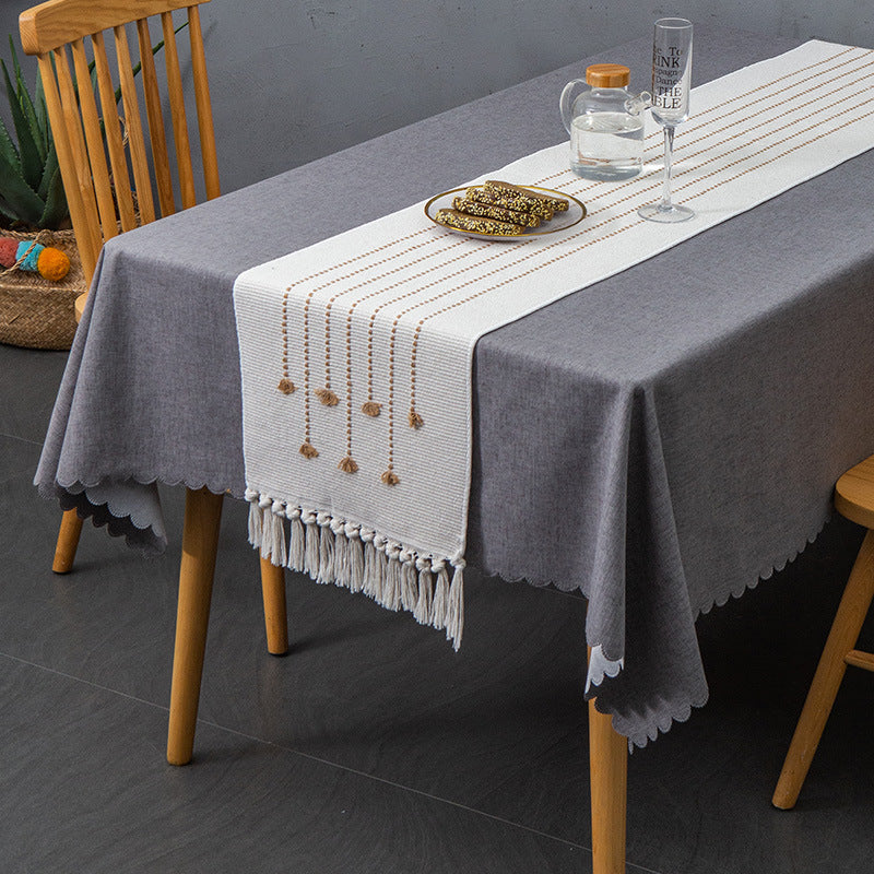 Decorative table runner in Scandinavian-minimalist design with macrame fringes