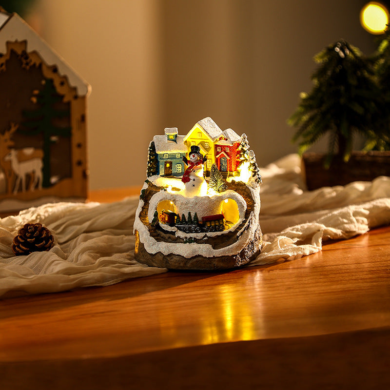 Illuminated Christmas village scene with snowman