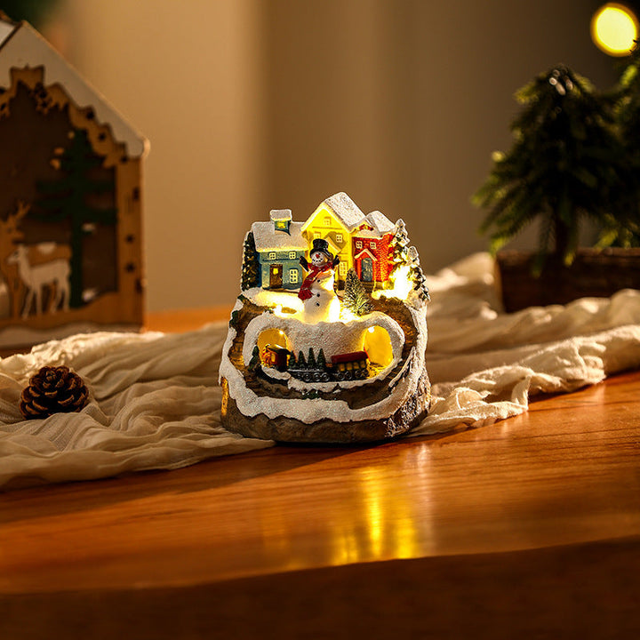 Illuminated Christmas village scene with snowman