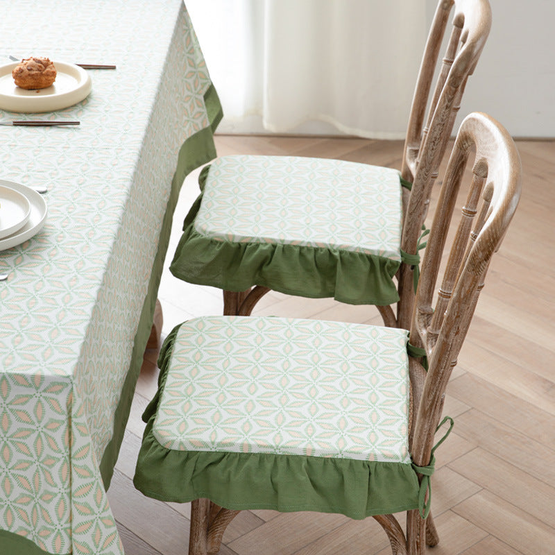 Padded chair cushion with ties, ruffled edge and embroidered hole pattern look