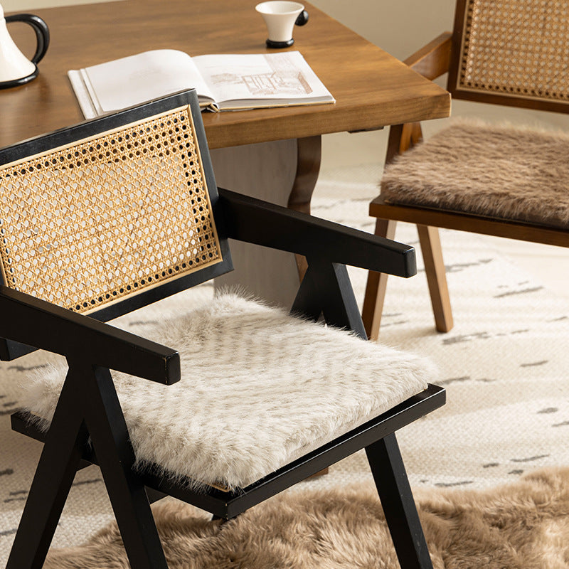 Square chair cushion made of cozy artificial fur with non-slip base and strap attachment