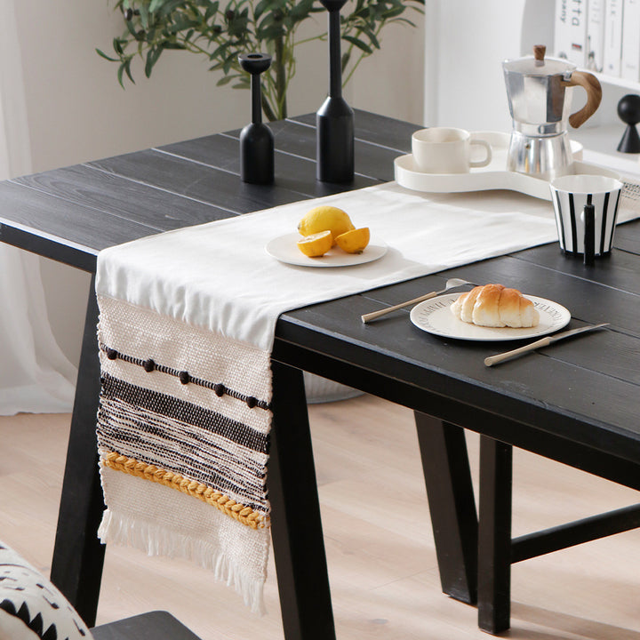 Woven decorative table runner with textured fringes and tactile weaving pattern