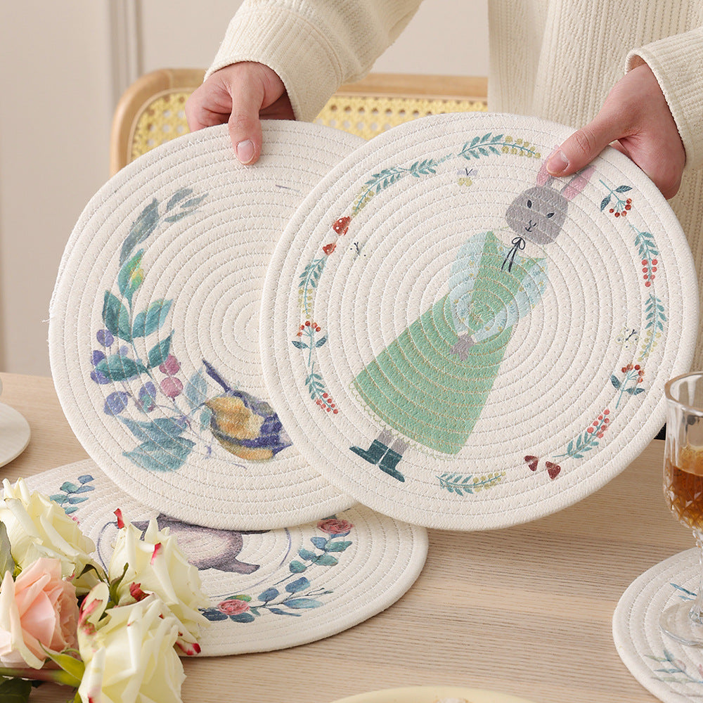 Round placemat made of woven cotton with a cute rhinoceros illustration and floral wreath