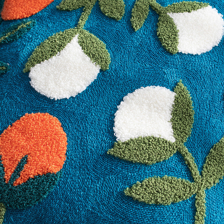 Woven decorative pillow cover with hand-tufted floral appliqués and bouclé relief