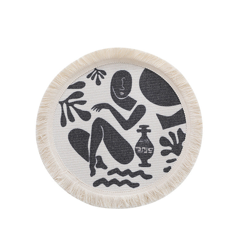 Round woven placemat with fringes and abstract figure motif