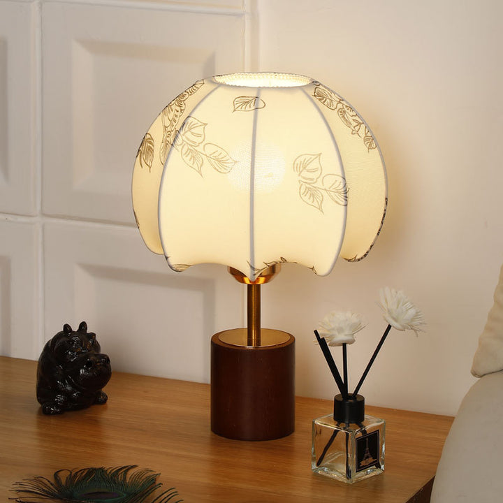 Sculptural table lamp with wooden base, brass stem, and cardboard shade